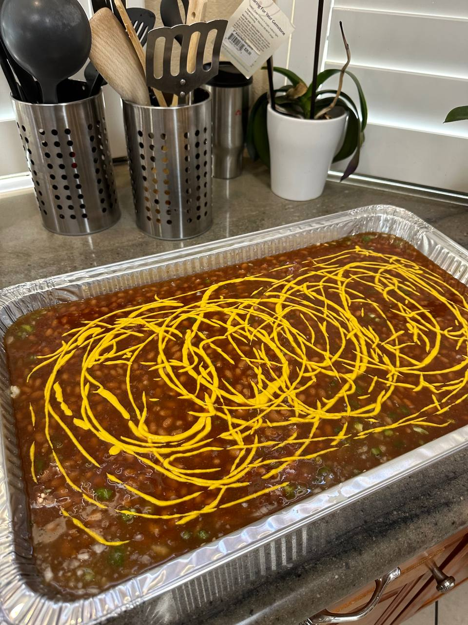 Tray of Go Hard Grills BBQ baked beans with mustard drizzle